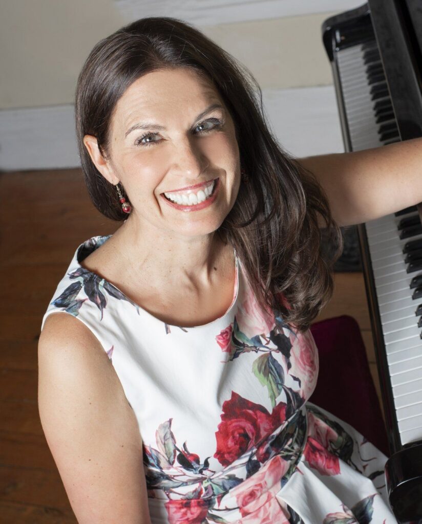 Jen Smele seated beside a piano keyboard